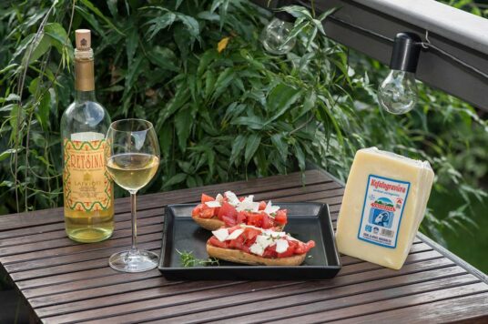 Greckie dakos, wino i ser na stole w ogrodzie.
